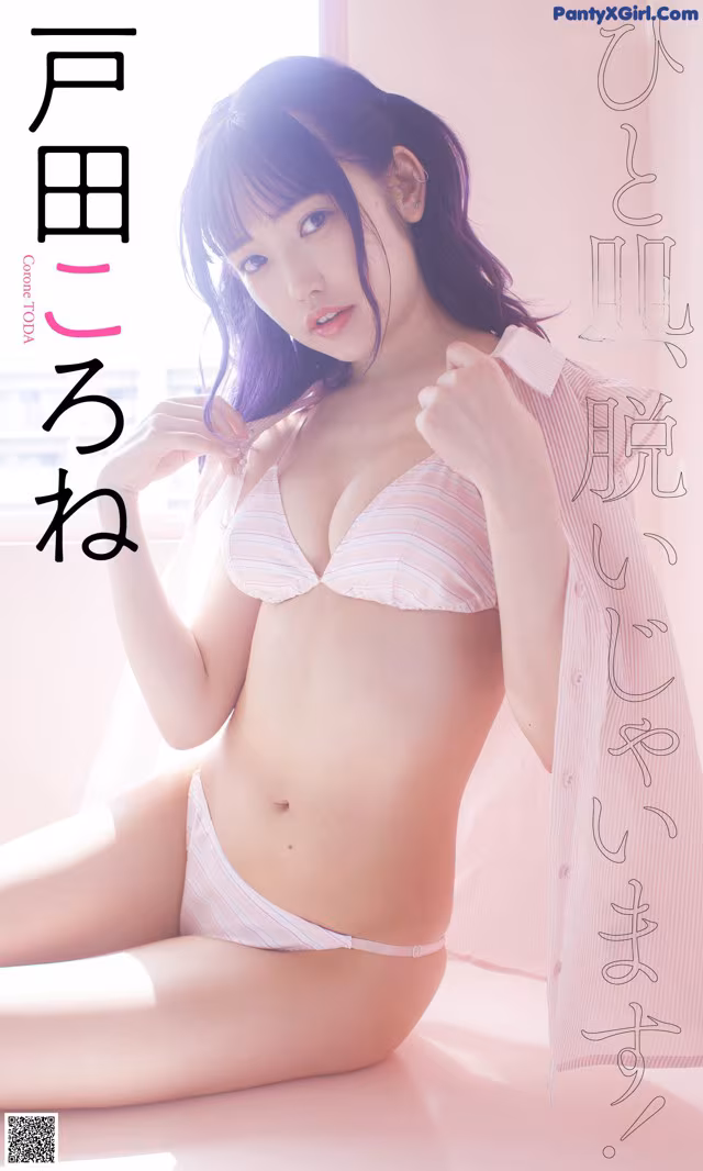 A woman in a pink and white striped bikini sitting on a bed.