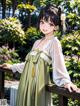 A woman in a green dress standing on a wooden railing.