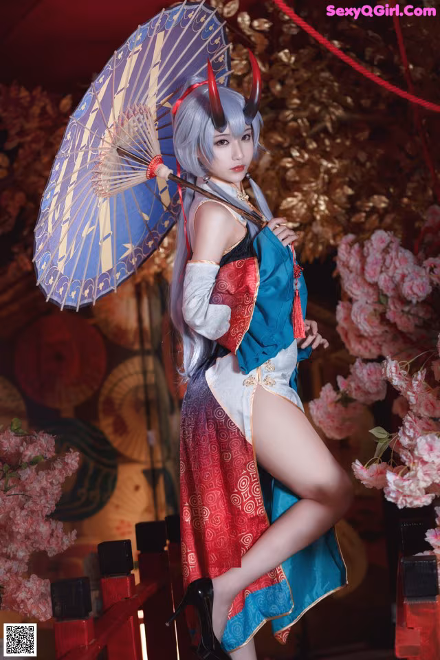 A woman in a blue and red kimono holding an umbrella.