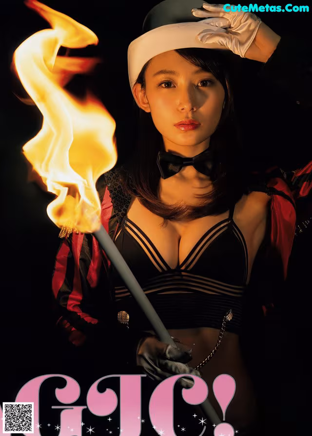 A woman in a sailor outfit holding a fire stick.