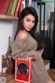 A woman sitting on a table holding a book.