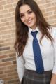 A young woman wearing a white shirt and a blue tie.