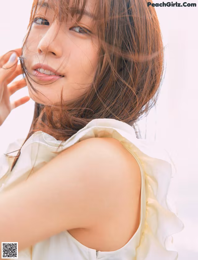 A woman in a white dress posing for a magazine.
