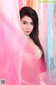 A woman in a pink lingerie posing for a picture.