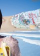 A woman holding a banana on the beach.