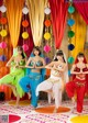 A group of women in colorful outfits dancing on a stage.