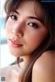 A close up of a woman with long brown hair.