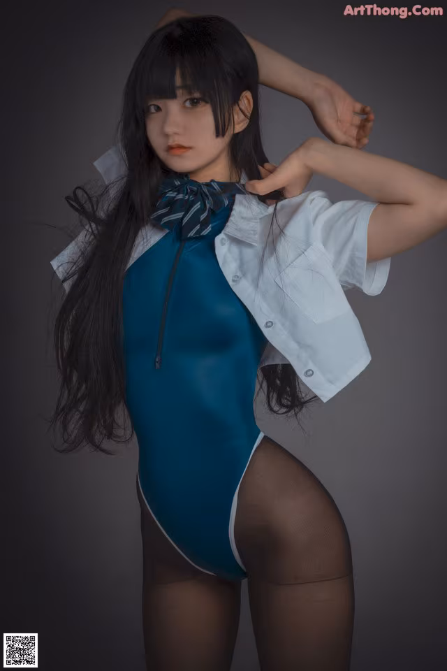 A woman in a blue bodysuit and a white shirt.